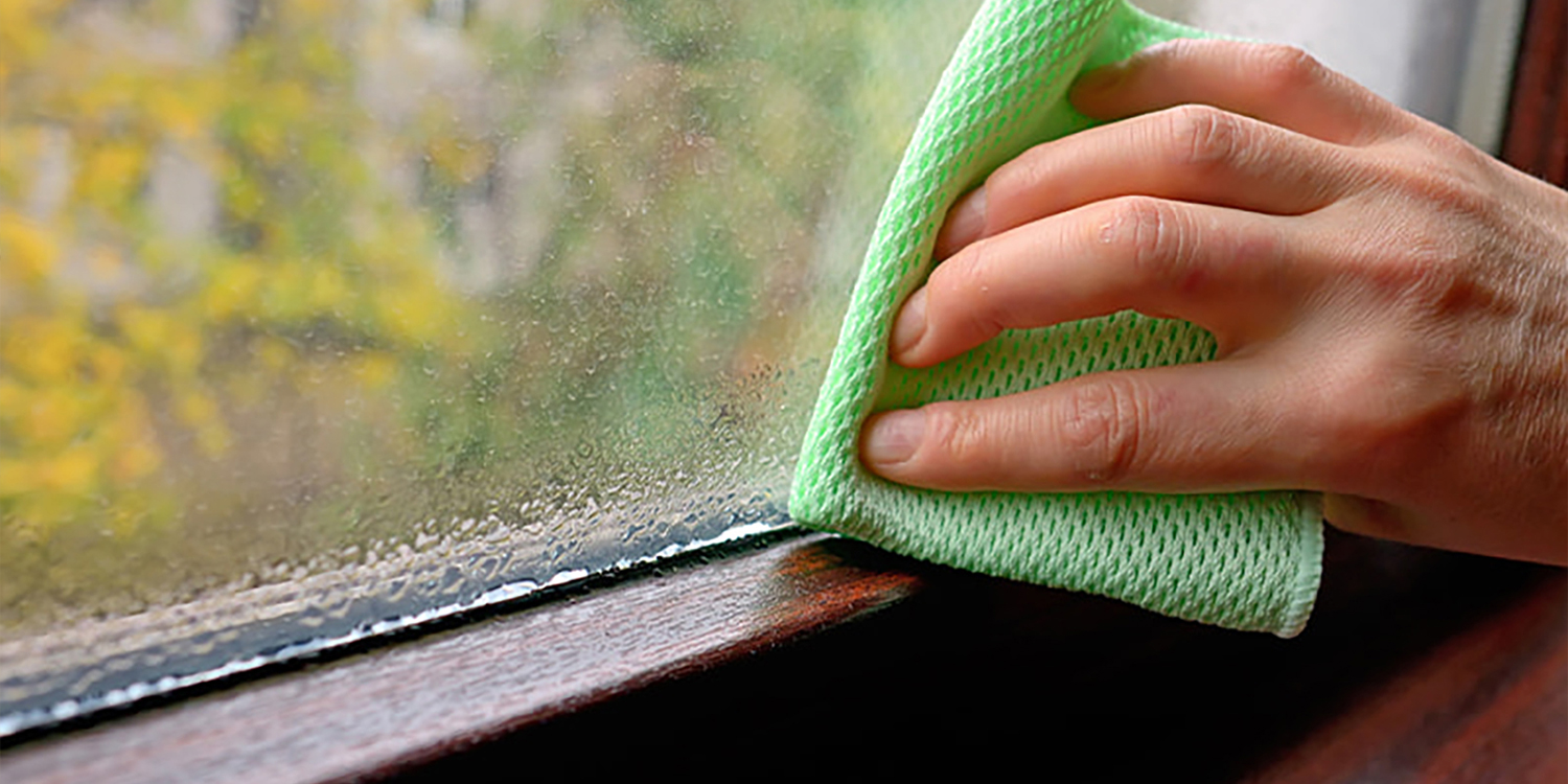 Window showing condensate with cloth wiping water away