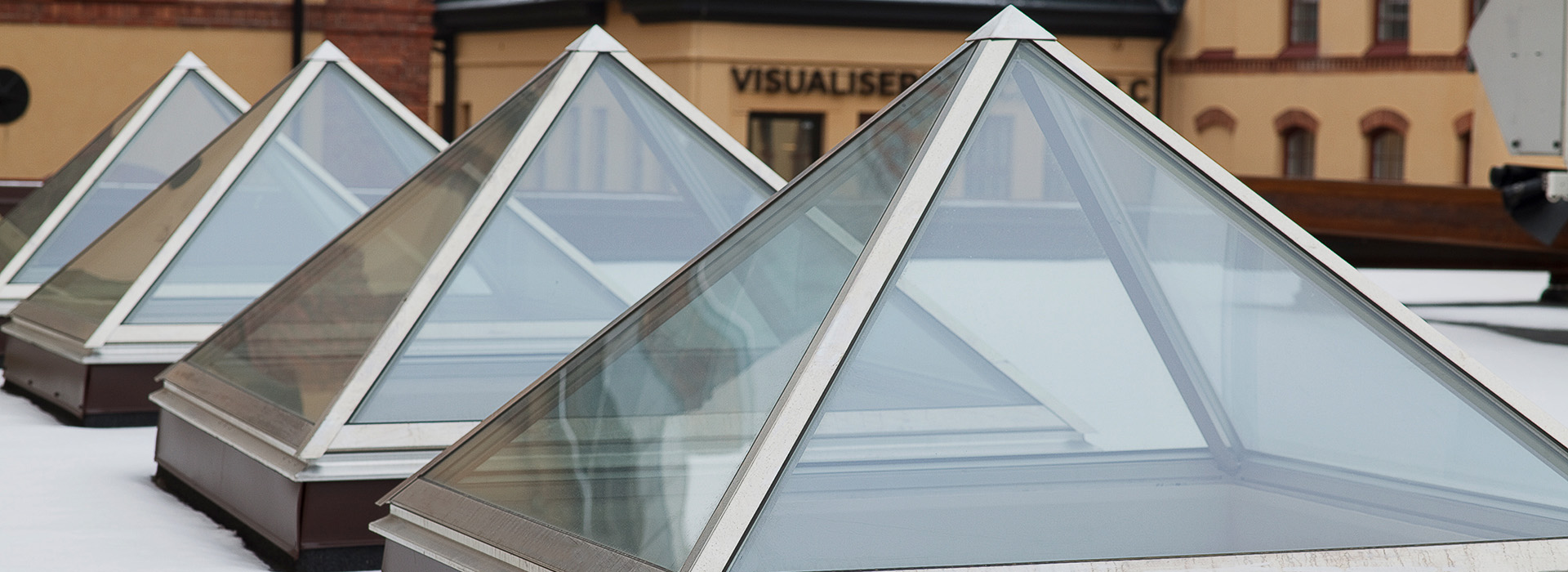 pyramid roof lantern on a roof with snow around skylight in flat roof