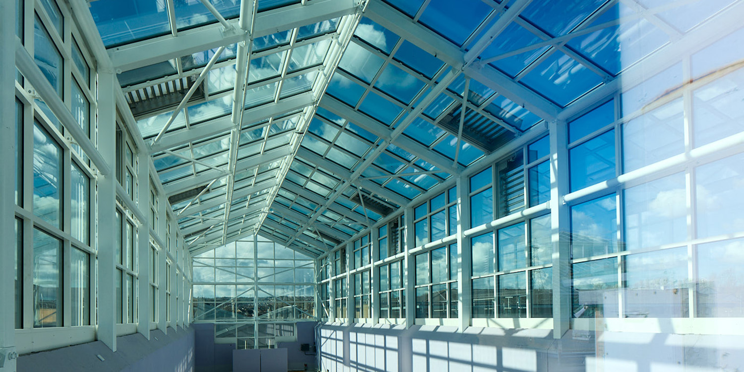 Internal tunnel view of glass roof with glazed vertical uprights