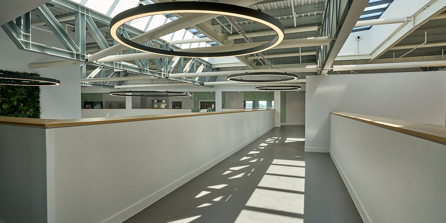 Natural daylight entering a modern school atrium through LAMILUX glass rooflights