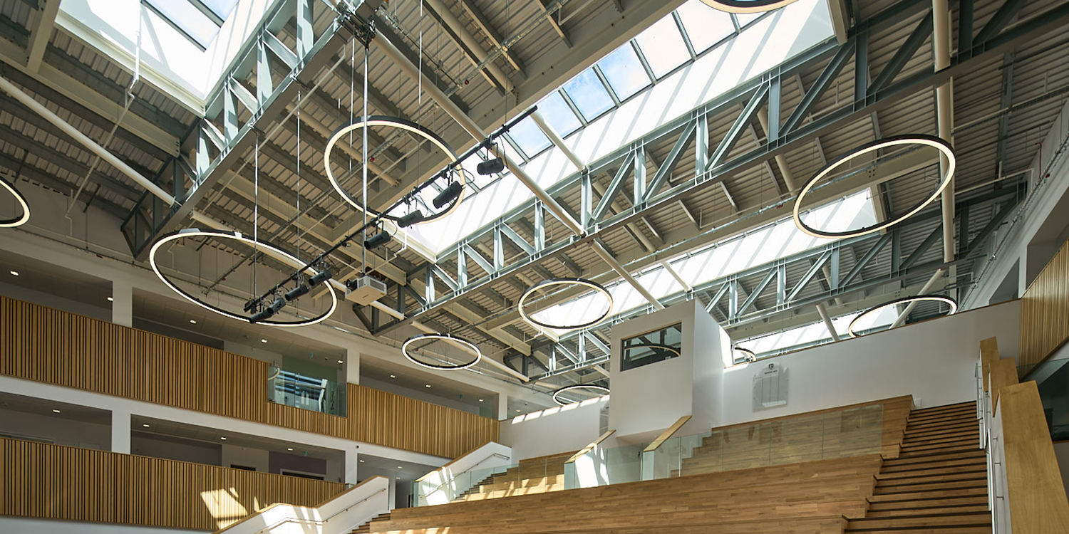 Mono pitched rooflight rows with circular lights in ceiling