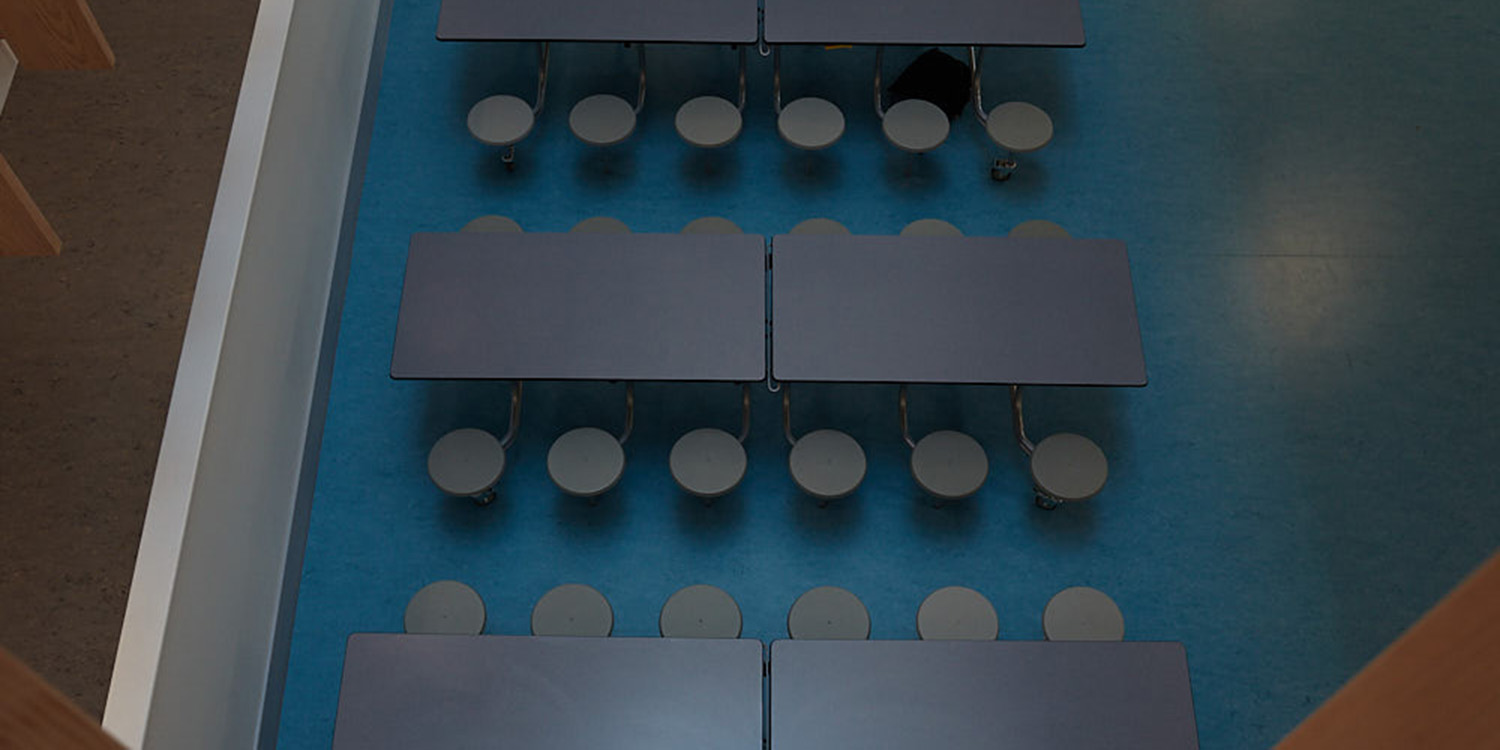 School canteen seating area with benches and circular chairs