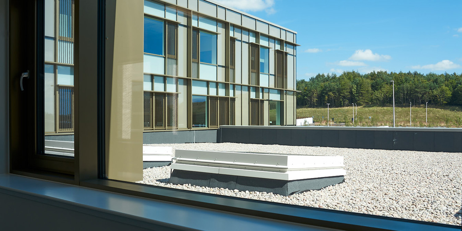 Looking out of window onto a roof with a square rooflight on it
